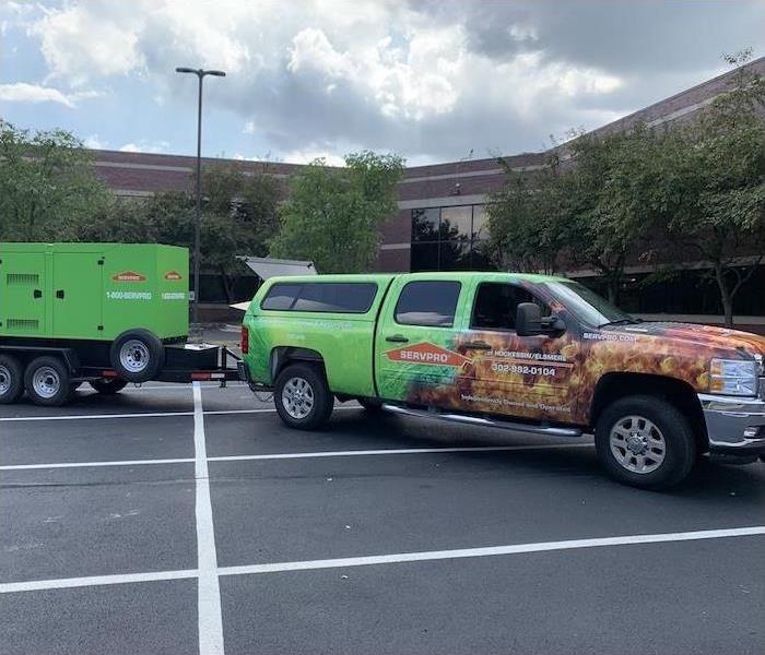 SERVPRO truck in a parking lot towing large equipment