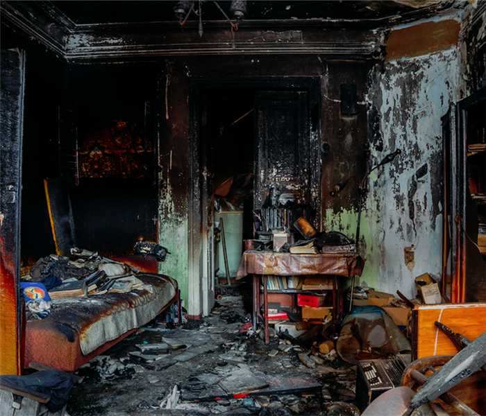 a fire damaged room with soot and debris everywhere